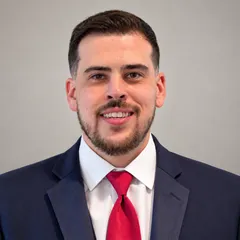 Jonathan Fiorante smiling in a navy suit and red tie